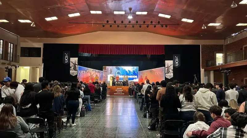 Auditorio con el público en sus lugares y pantallas en el escenario