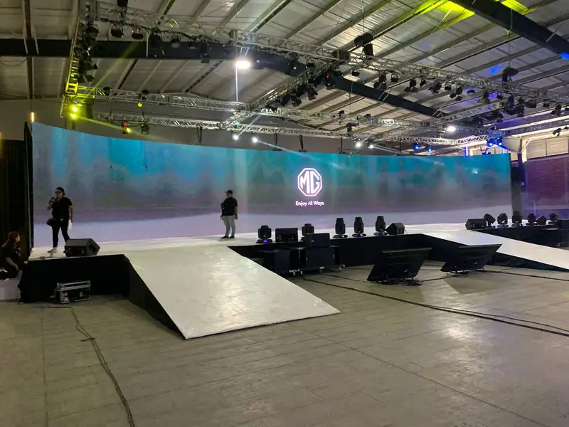 Salón con muro LED curvo, pasarela y estructura de iluminación durante el montaje